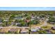 Neighborhood aerial view shows a house surrounded by lush trees in a residential area with pond at 6547 Samoa Dr, Sarasota, FL 34241