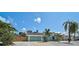 Charming turquoise home featuring a well-manicured lawn with tropical landscaping and a two-car garage at 6924 34Th W Ave, Bradenton, FL 34209