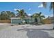 Charming turquoise home featuring a well-manicured lawn with tropical landscaping and a two-car garage at 6924 34Th W Ave, Bradenton, FL 34209