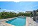 Lush backyard featuring a sparkling pool, comfortable lounge chairs, and a shaded dining area at 6924 34Th W Ave, Bradenton, FL 34209