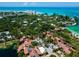 Panoramic aerial view of a coastal community featuring lush greenery and stunning ocean views at 7 Sandy Cove Rd, Sarasota, FL 34242
