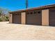 Three-car garage with brown doors provides ample parking and storage space with a gravel driveway at 7 Sandy Cove Rd, Sarasota, FL 34242