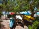 Colorful kayaks neatly stored near a beach, surrounded by lush green foliage at 7 Sandy Cove Rd, Sarasota, FL 34242