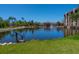 A tranquil pond featuring lush landscaping, a decorative fountain, and charming waterside buildings at 7 Sandy Cove Rd, Sarasota, FL 34242