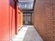 Exterior walkway between brick walls with a skylight and view towards a sliding glass door at 7 Sandy Cove Rd, Sarasota, FL 34242