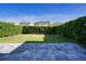 Backyard featuring a neatly arranged paver patio and well-maintained green hedge for privacy at 7168 Chatum Light Run, Bradenton, FL 34212