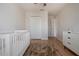 This bedroom features wood-look floors, a ceiling fan, and a white crib with a shag rug at 7168 Chatum Light Run, Bradenton, FL 34212