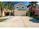 Charming two-story home boasts a well-manicured lawn and beautiful palm trees, creating a welcoming curb appeal at 7168 Chatum Light Run, Bradenton, FL 34212