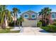 Charming two-story home boasts a well-manicured lawn and beautiful palm trees, creating a welcoming curb appeal at 7168 Chatum Light Run, Bradenton, FL 34212