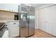Kitchen area featuring a large stainless steel refrigerator, white cabinets, and a pantry at 7168 Chatum Light Run, Bradenton, FL 34212