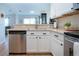 Open concept kitchen featuring stainless steel appliances, white cabinets, and stone backsplash at 7168 Chatum Light Run, Bradenton, FL 34212