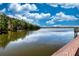Scenic lake view with trees, calm water, and a clear blue sky reflecting off the surface at 7168 Chatum Light Run, Bradenton, FL 34212