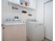 Bright laundry room with modern washer and dryer, storage and decor at 7168 Chatum Light Run, Bradenton, FL 34212
