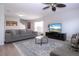 Bright living room with a large gray sofa, patterned rug, and a ceiling fan at 7168 Chatum Light Run, Bradenton, FL 34212