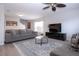 Bright living room with a large gray sofa, patterned rug, and a ceiling fan at 7168 Chatum Light Run, Bradenton, FL 34212