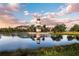 This pond features a lighthouse in the middle, palm trees, and gorgeous landscaping around the water at 7168 Chatum Light Run, Bradenton, FL 34212