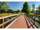 Scenic view of a wooden bridge over a pond with lush greenery and clear blue skies at 7168 Chatum Light Run, Bradenton, FL 34212