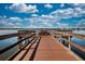 Picturesque wooden dock on a calm lake with a bench, railings, and clear blue skies at 7168 Chatum Light Run, Bradenton, FL 34212