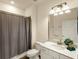 Cozy bathroom featuring a shower with a patterned curtain, white vanity, and sink at 7425 Divot Loop, Lakewood Ranch, FL 34202