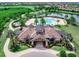 Gorgeous aerial view of a grand community clubhouse with lush surroundings, pool, and golf course at 7425 Divot Loop, Lakewood Ranch, FL 34202