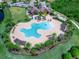 Aerial view of a resort-style community pool with palm trees and plenty of lounge seating at 7425 Divot Loop, Lakewood Ranch, FL 34202