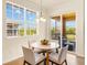 Cozy dining area featuring a round table, four chairs, and natural light from large windows at 7425 Divot Loop, Lakewood Ranch, FL 34202