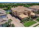 Beautiful exterior view of a home featuring lush landscaping, paved driveway, and a serene lake view at 7425 Divot Loop, Lakewood Ranch, FL 34202