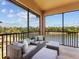 Outdoor patio with cushioned seating that has a lake view at 7425 Divot Loop, Lakewood Ranch, FL 34202