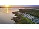 Stunning aerial view of waterfront condos with lush landscaping and a serene sunset backdrop at 78 Tidy Island Blvd, Bradenton, FL 34210