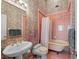 Retro bathroom with a floral wallpaper, pink tile and a classic tub and vanity at 78 Tidy Island Blvd, Bradenton, FL 34210