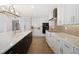 Bright kitchen featuring white cabinets, stone counters, stainless steel appliances, and a stylish tile backsplash at 78 Tidy Island Blvd, Bradenton, FL 34210