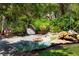 Beautifully landscaped grounds with a wooden bridge over a small pond, surrounded by lush greenery and trees at 78 Tidy Island Blvd, Bradenton, FL 34210