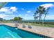 A luxurious waterfront pool with lounge chairs offers stunning views of the water and lush tropical foliage at 78 Tidy Island Blvd, Bradenton, FL 34210