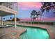 Inviting pool with shimmering water, surrounded by a stone patio overlooking serene water views at 78 Tidy Island Blvd, Bradenton, FL 34210