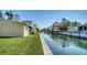 Canal-front property with lush lawn and mature palm trees along a serene waterway at 780 Jungle Queen Way, Longboat Key, FL 34228