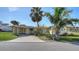 Inviting single-story home featuring a covered carport, well-kept lawn, and tropical landscaping at 780 Jungle Queen Way, Longboat Key, FL 34228