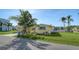 Charming single-story home with a well-maintained lawn and lush tropical landscaping with palm trees at 780 Jungle Queen Way, Longboat Key, FL 34228