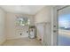 Utility room featuring a water heater, window, and door to the backyard at 780 Jungle Queen Way, Longboat Key, FL 34228