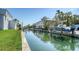 Scenic waterfront view featuring a canal with boat dock, waterfront home, and lush tropical landscaping at 780 Jungle Queen Way, Longboat Key, FL 34228