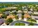 Aerial view showcasing the neighborhood with lush tree coverage, lakes, and beautiful homes at 7804 Edmonston Cir, University Park, FL 34201