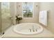 Bright bathroom features a tiled tub with a window and natural light at 7804 Edmonston Cir, University Park, FL 34201