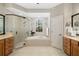 Bathroom with a glass walk-in shower, tub, and wood vanity at 7804 Edmonston Cir, University Park, FL 34201