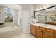 Bathroom features a large wood vanity, tub, and walk-in glass shower at 7804 Edmonston Cir, University Park, FL 34201