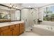 Bathroom features a wooden vanity, walk-in shower, and large tub at 7804 Edmonston Cir, University Park, FL 34201