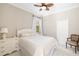Bright bedroom with white furnishings, including a bed, dresser, and chair, under a window at 7804 Edmonston Cir, University Park, FL 34201