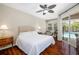 Primary bedroom with a ceiling fan and sliding glass door to a screened in lanai at 7804 Edmonston Cir, University Park, FL 34201