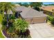 Aerial view of a single Gathering home, featuring a three-car garage and lush landscaping at 7804 Edmonston Cir, University Park, FL 34201