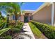 Charming home entrance with a walkway lined with lush plants and a decorative door at 7804 Edmonston Cir, University Park, FL 34201