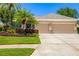 Charming single-story home with a three-car garage and lush tropical landscaping at 7804 Edmonston Cir, University Park, FL 34201