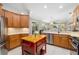 Open kitchen design with island, wood cabinets, and views of the outdoor living space at 7804 Edmonston Cir, University Park, FL 34201